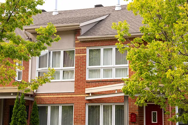 Fenêtres de la collection Verdun sur maison en brique rouge. Fabrication locale au Québec.